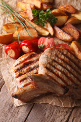 Grilled pork steak with potatoes close up on paper. Vertical
