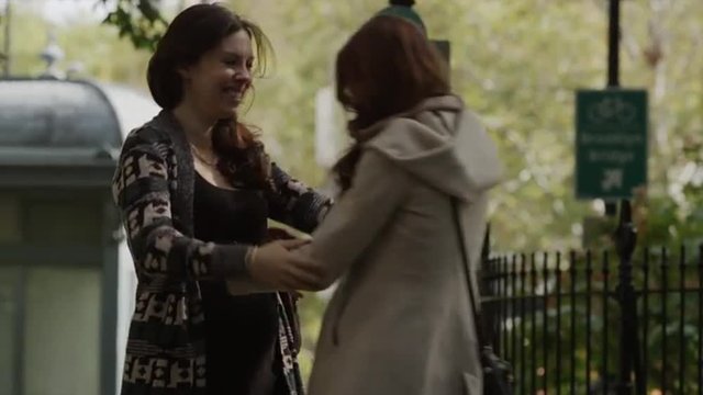 Medium shot of pregnant woman greeting friend in park / New York City, New York, United States
