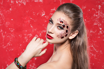 creative fashion girl with red stones on the face, hair
