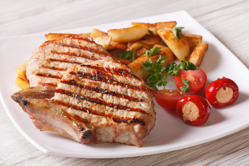Grilled pork steak with potatoes and vegetables on a plate