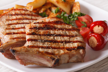 Grilled pork steak with potatoes on a plate, macro
