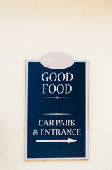 Restaurant sign advertising 'Good Food' and sign for car park