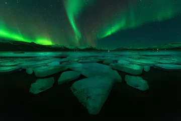 Fotobehang Northern lights aurora borealis in the night sky over beautiful © JKLoma
