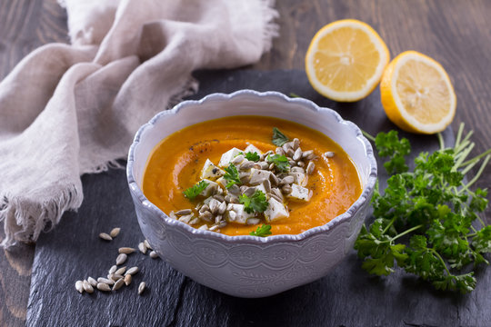 Carrot soup with feta cheese, sunflower seeds and parsley