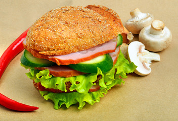 Hamburger with ham, mushrooms, cucumber, salad, chili pepper