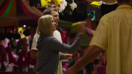 Medium shot of young couple playing dart game at amusement park / Salt Lake City, Utah, United States