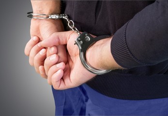 Handcuffs. Arrested man hands close up