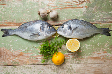 Two fresh fishes lying on a wooden table