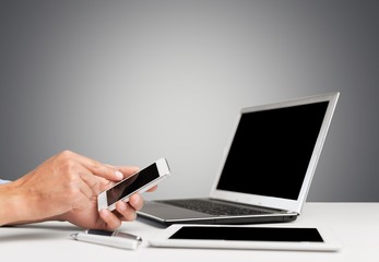 Laptop. Man hand working with smartphone with computer