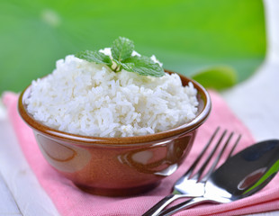 Cooked white rice garnished with mint in a ceramic bowl