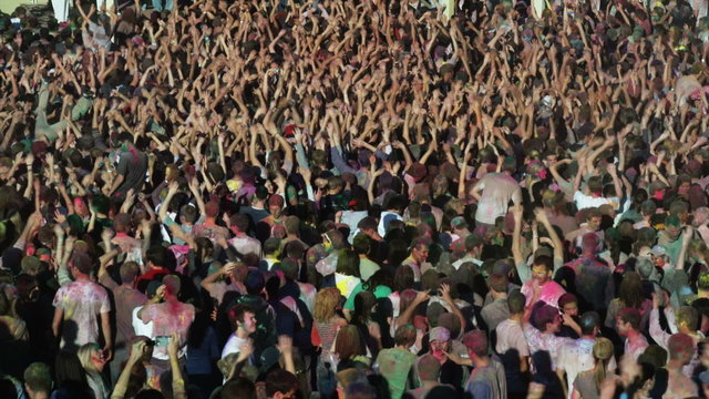 crowd of people waving their arms in the air