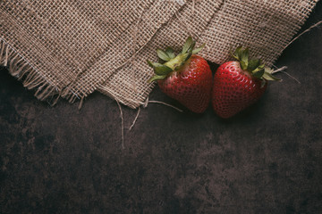 Two strawberries on a rustic background