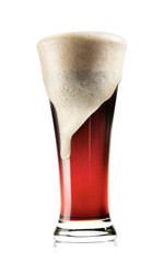 Tall glass of dark beer with foam
