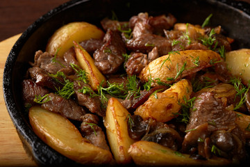 Potato wedges fried with meat and mushrooms