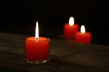 Obraz na płótnie Canvas Hope illuminatesThree candles on the old wooden table