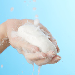 Female hand in foam of shower gel with soap
