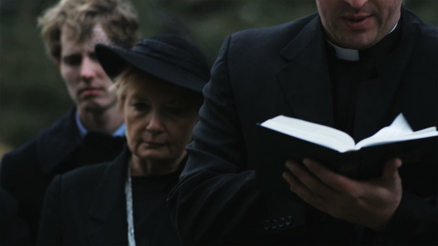 Priest Giving A Eulogy At A Funeral