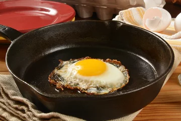 Crédence de cuisine en verre imprimé Oeufs sur le plat Fried egg in a cast iron skillet