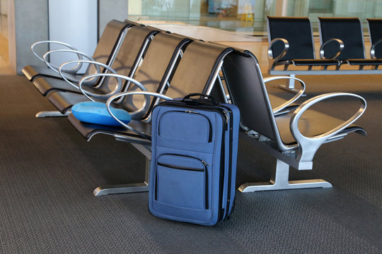 Blue suitcase at an airport lobby.