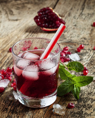 Fresh red juice cocktail with pomegranate seeds, mint and ice, s