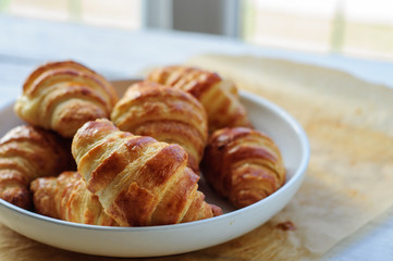 Fresh baked croissants on baking paper