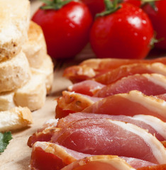 Pork smoked ham and tomatoes on the board, selective focus