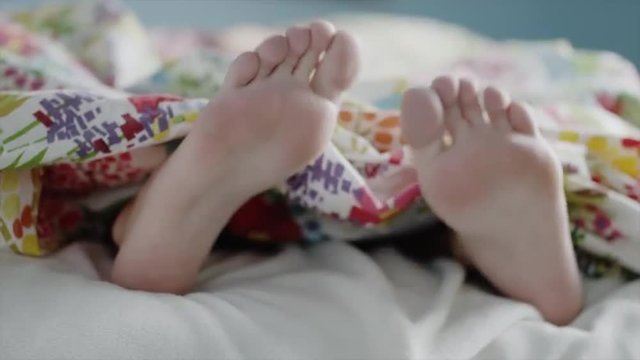 Close up of teenage girl&iacute;ęs feet dancing under blanket / Sandy, Utah, United States