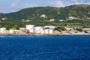 White Fuel Tanks on Green Coast by Blue Water