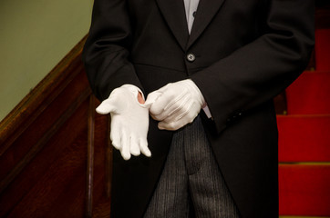 Butler zieht weiße Handschuhen an