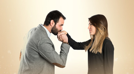 man kissing a woman's hand over white background.