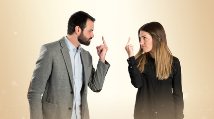 Young businessperson doing the horn sign over white background