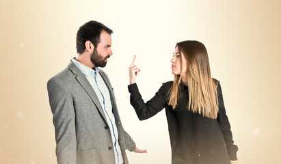 Girl doing the horn sign at her boyfriend over white background