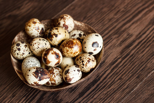 The quail eggs in a tray on a wooden table
