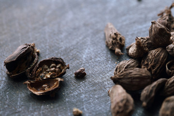 Seeds of black cardamom on the dark wooden table