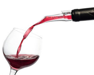 Red wine pouring into a wine glass isolated on white