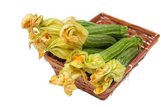 Courgettes with flowers in brown basket isolated
