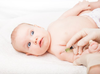 Pediatrician giving baby girl intramuscular injection in arm