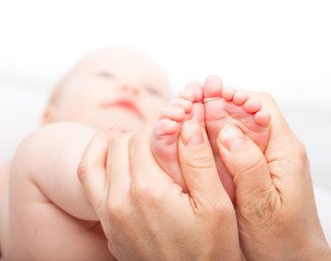 Baby girl receiving foot massage from a female massage therapist