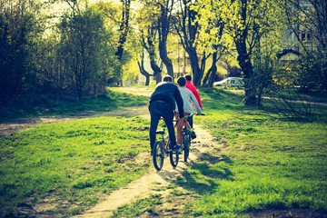 Fototapeta premium Vintage photo of boys riding on bikes in park