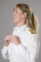 Woman airline officer buttoning white uniform shirt