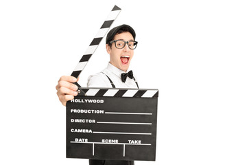 Excited movie director posing behind a clapperboard