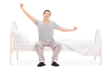 Cheerful man waking up from sleep and stretching