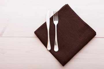 Cutlery, tablecloth on white wooden table for dinner.