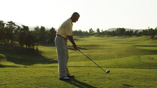 senior golfer teeing off
