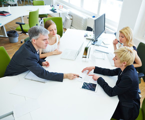 Team diskutiert am Schreibtisch beim Meeting
