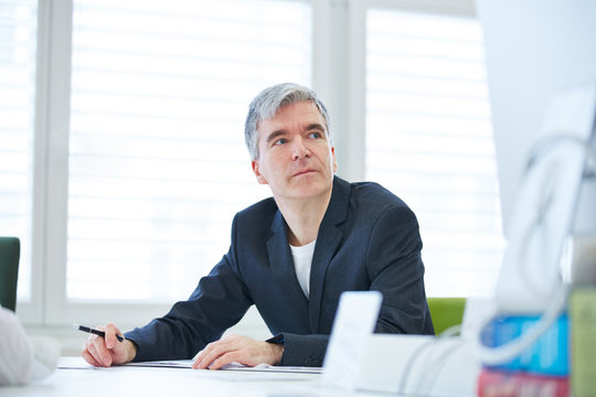 Gesch&auml;ftsmann am Tisch beim Nachdenken