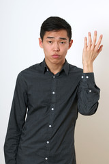 Frustrated young Asian man gesturing with his hand