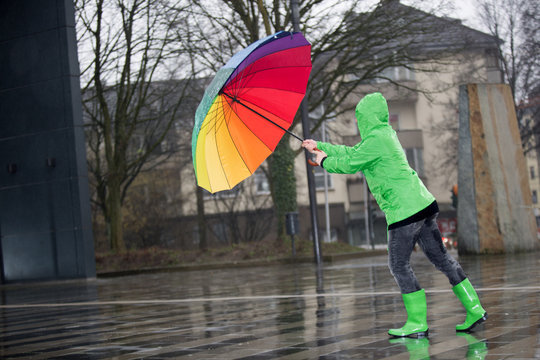 Mit buntem Regenschirm gegen das Unwetter in der Stadt