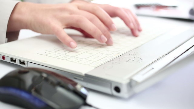 Business person working on laptop in office environment