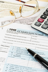 Tax form with glasses, pen, and calculator